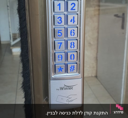 לוח מקשים מתכתי עם מספרים כחולים על דלת